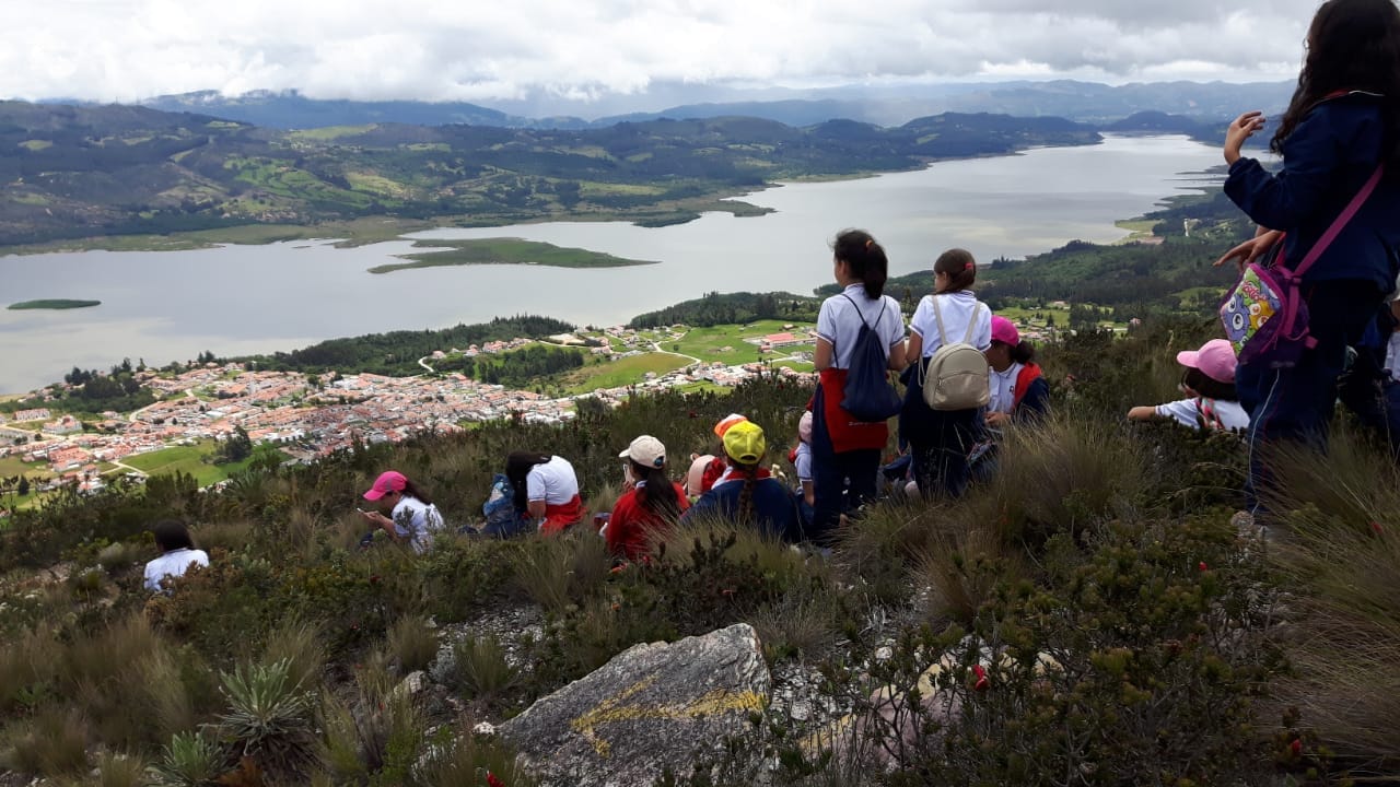 Estudiantes de colegio en un recorrido ambiental de Awalí School, realizando observación de flora y fauna en un ecosistema protegido.