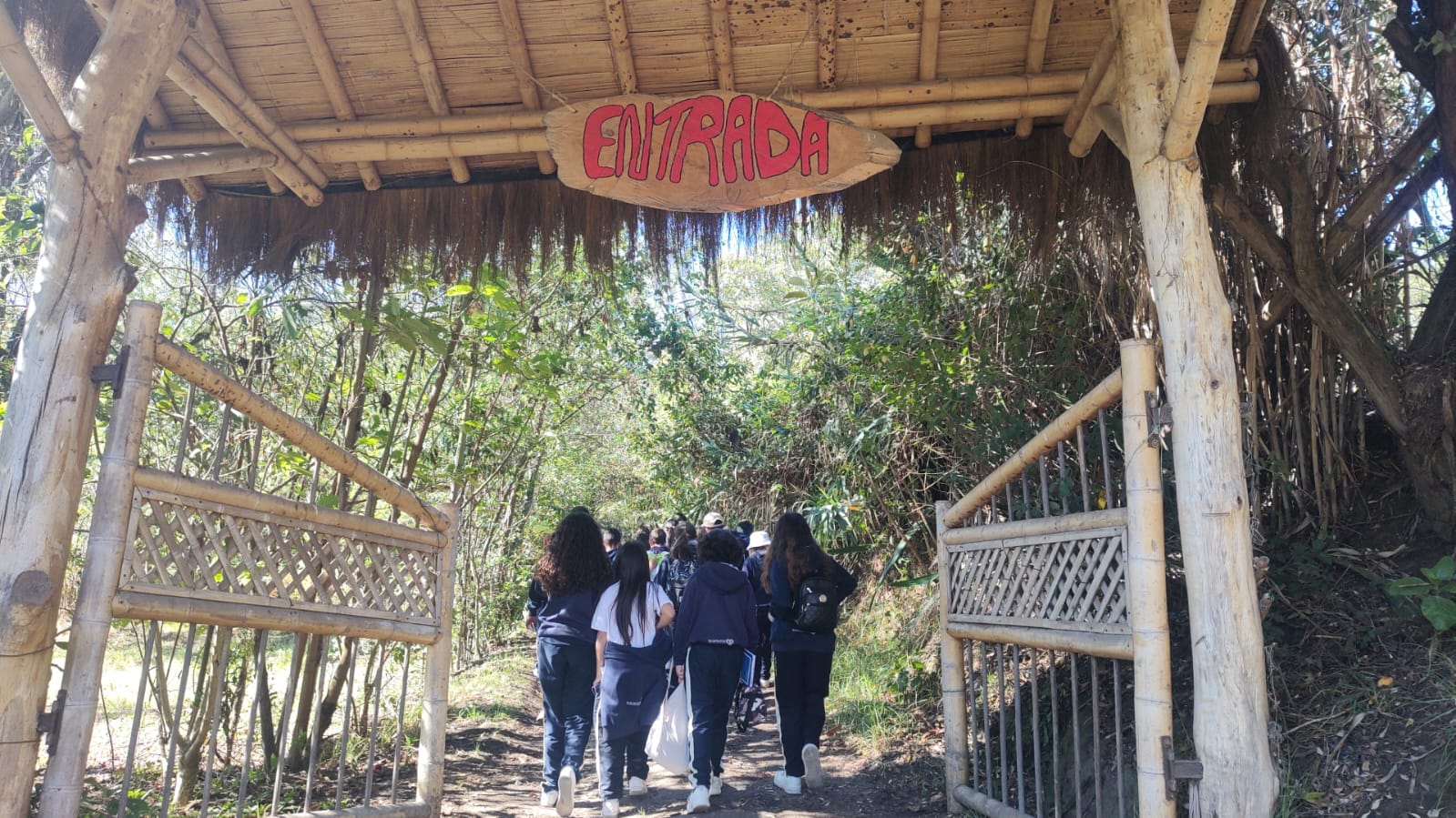 Estudiantes ingresando a un taller pedagógico con una comunidad indígena para aprender sobre tradiciones y respeto cultural.