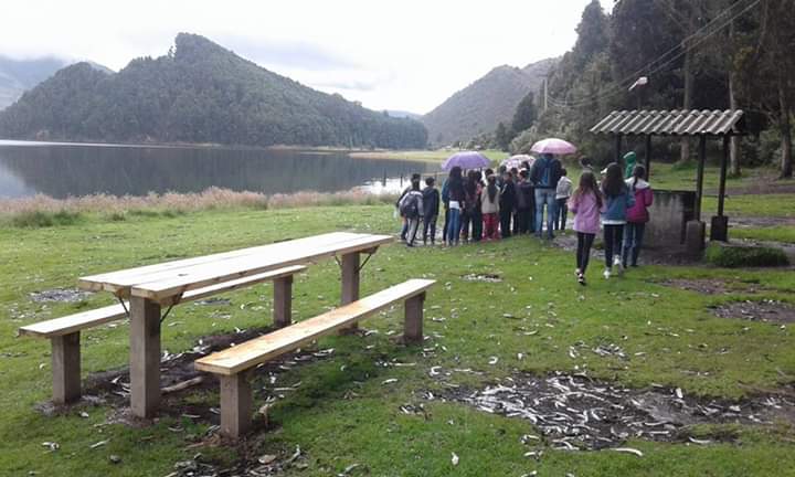 Estudiante registrando especies forestales en su diario de campo en la reserva del Embalse del Neusa.