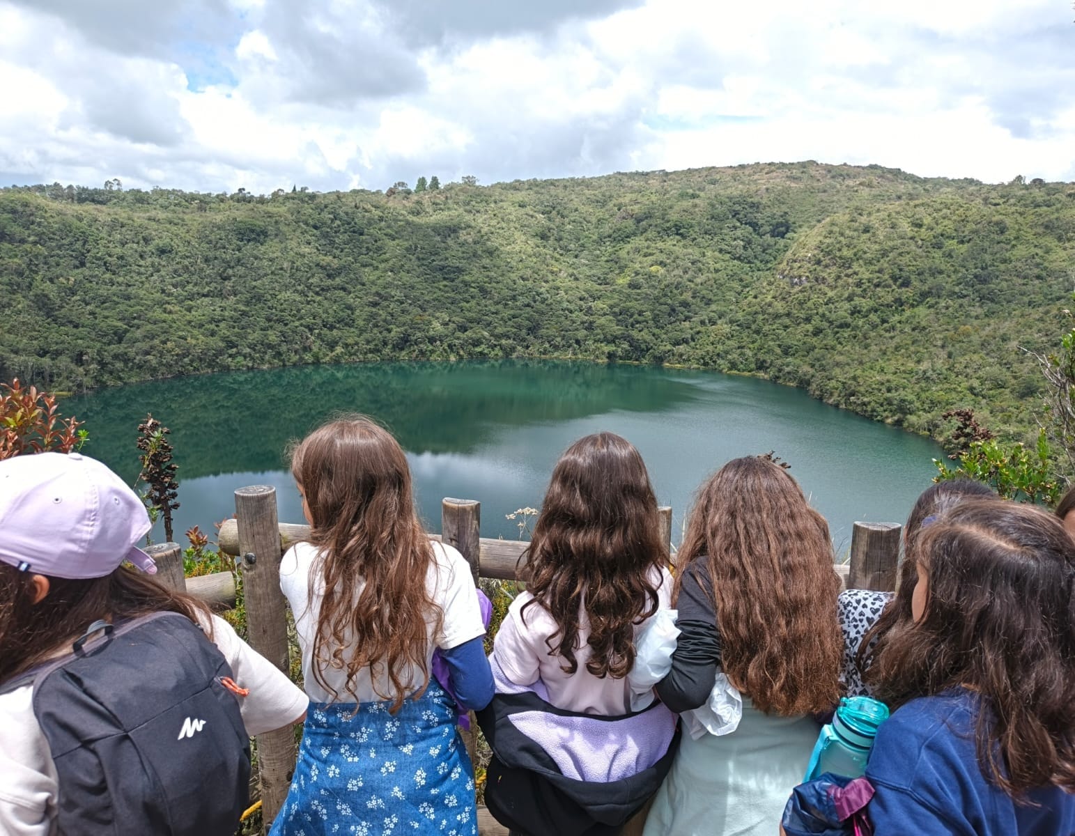 Estudiantes de colegio observando la Laguna de Guatavita y el paisaje del páramo andino durante una caminata pedagógica con Awalí School.