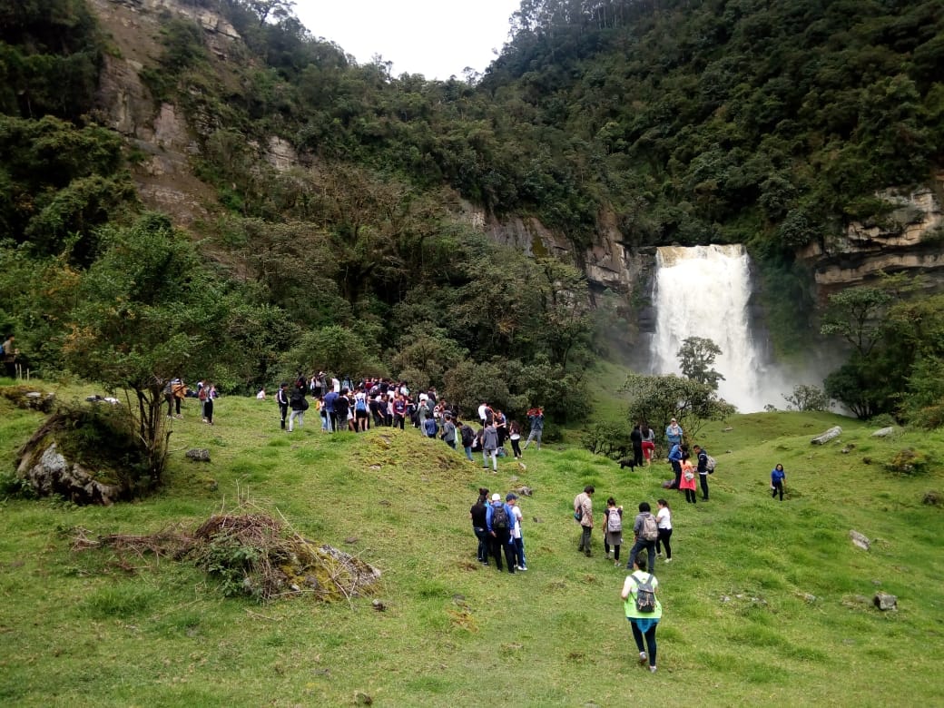 Estudiantes de colegio frente a la gran caída de agua de las Cascadas de Sueva, aprendiendo sobre el ciclo del agua con Awalí School.