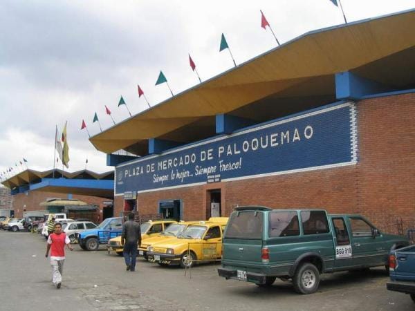 Grupo escolar realizando ejercicios prácticos de manejo de dinero y presupuesto en la Plaza de Paloquemao.