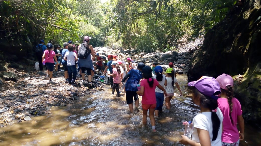 Grupo de estudiantes de Awalí School realizando un recorrido de senderismo y observación biológica en el entorno natural de la Quebrada del Tigre.