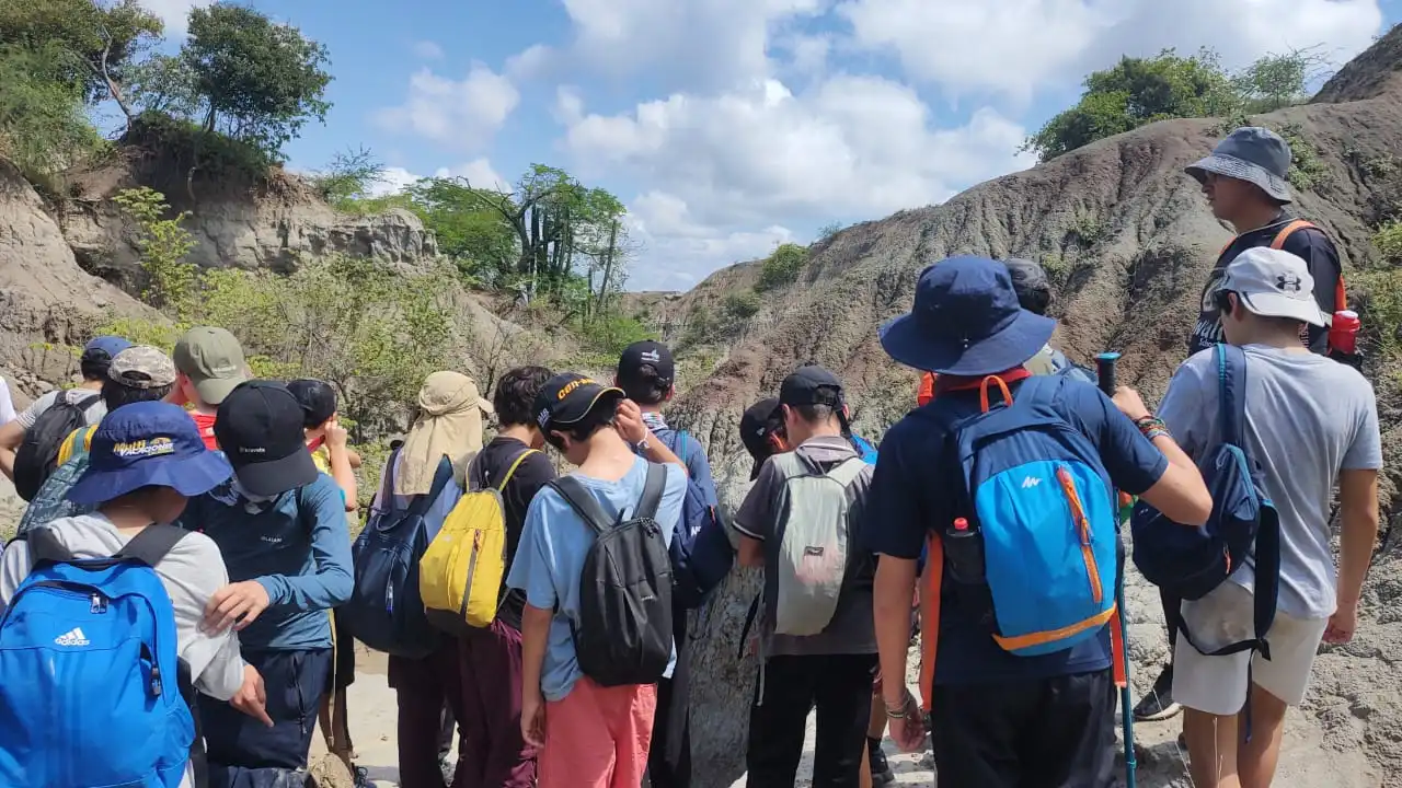 Estudiantes registrando evidencias de aprendizaje en bitácora de campo durante una salida pedagógica con Awalí School